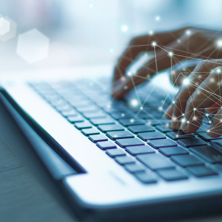 Hands typing on a laptop keyboard with digital network overlay.