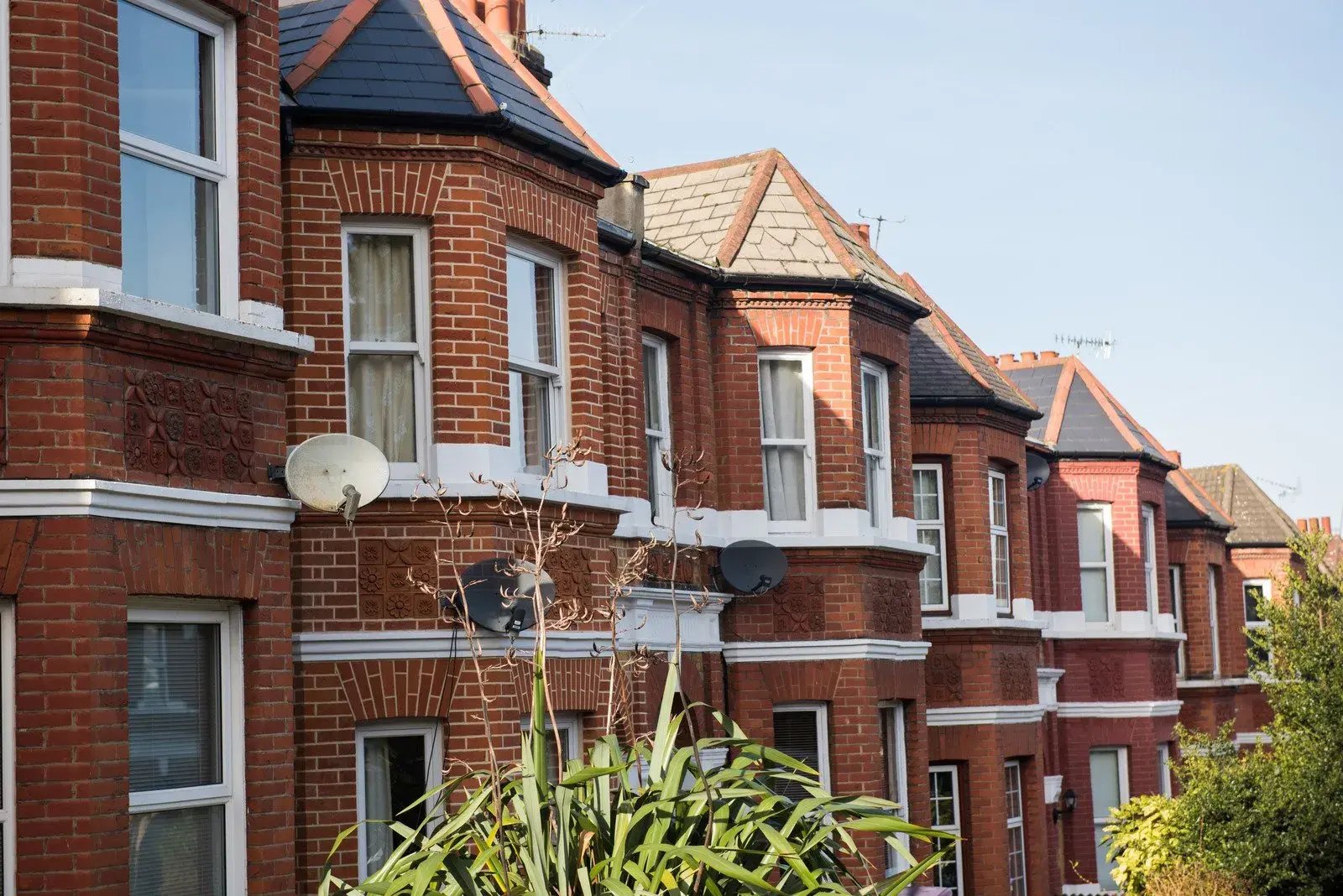 Row of red‑brick houses along a residential street