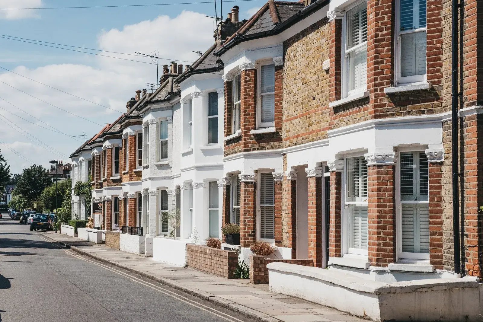 Photograph of residential houses along a street under a blue sky