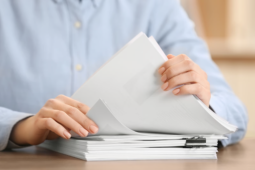 A housing professional reviews paperwork while choosing the right document management solution for their organisation.